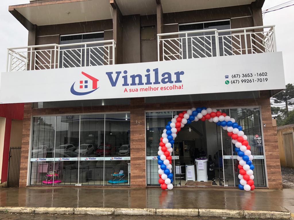 Fachada da Vinilar da Avenida, com o letreiro azul e vermelho e a entrada da loja